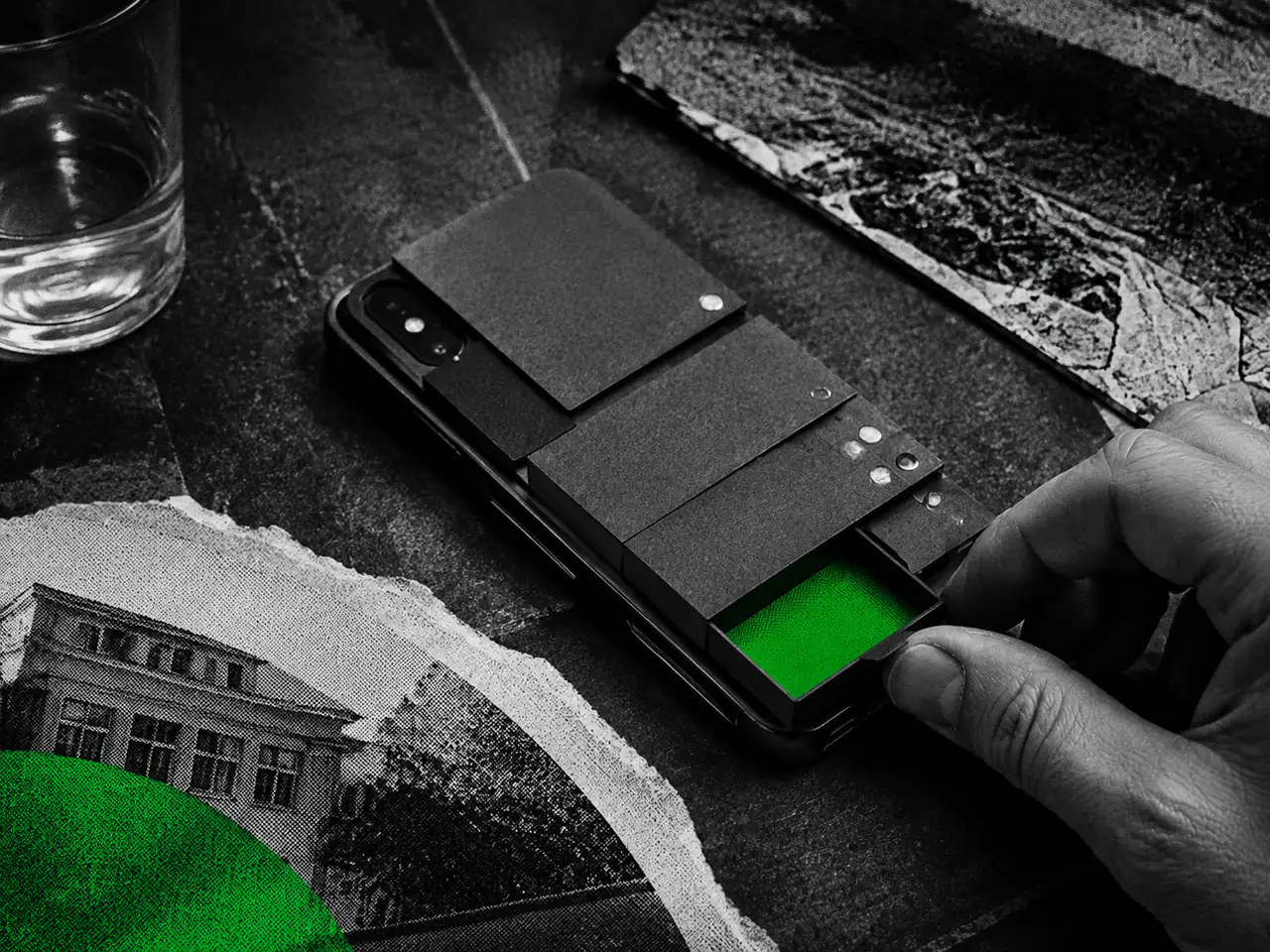 A hand opens a green-lined compartment in a layered phone, with a green collage fragment in the corner.