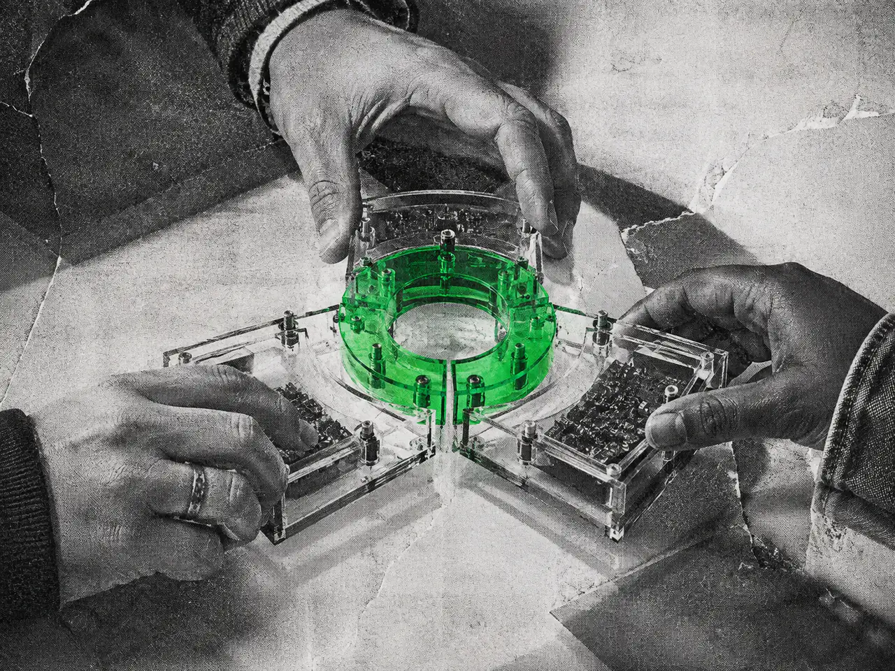 Three hands assemble transparent pieces around a green circular joint.